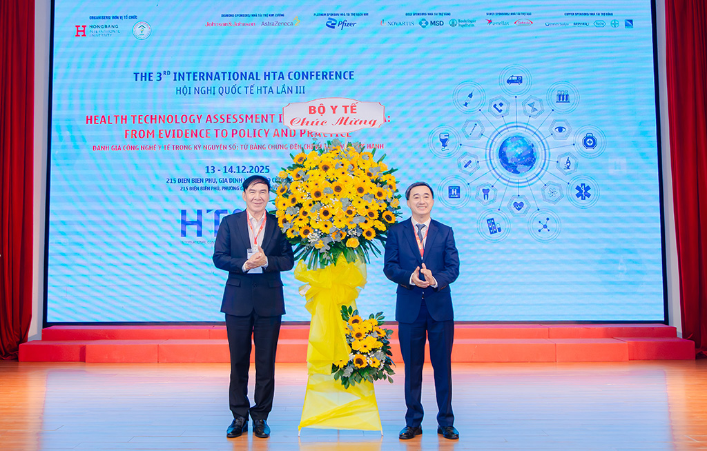 GS.TS Trần Văn Thuấn (trái), Thứ trưởng Bộ Y tế, tặng hoa chúc mừng Ban Tổ chức Hội nghị cho GS.TS.BS Phạm Văn Lình – Hiệu trưởng Trường Đại học Quốc tế Hồng Bàng.