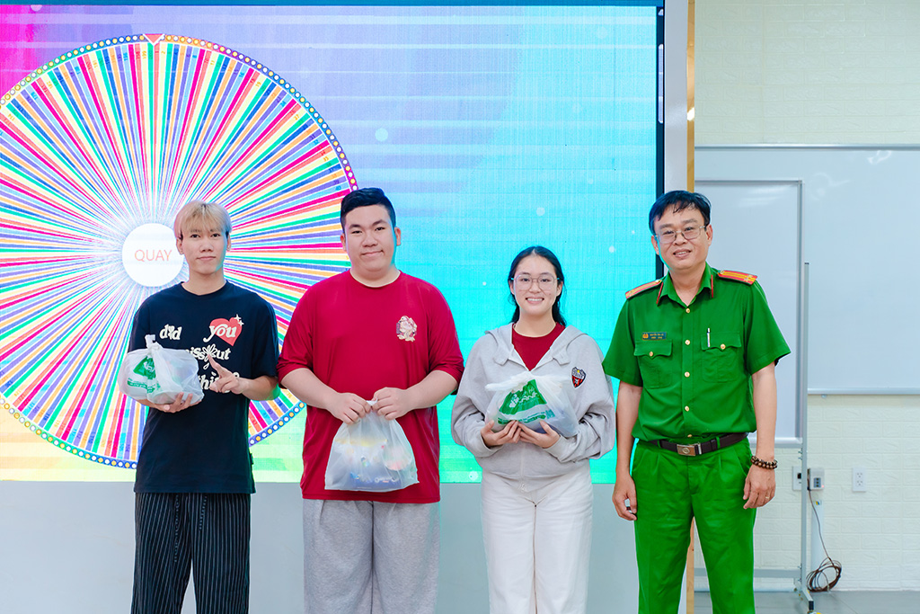 ThS. Trung tá Nguyễn Tấn Lộc (bìa phải) tặng quà cho các bạn sinh viên HIU tại talkshow